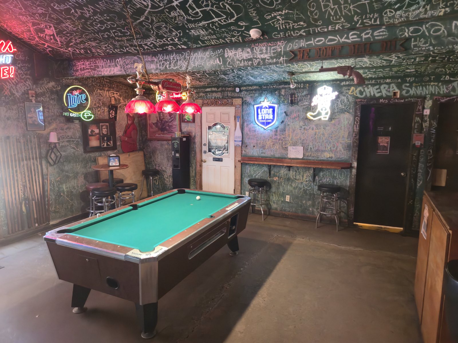 The back pool room, its walls and ceiling covered in decades of signatures